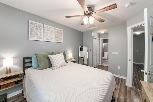 bedroom with a textured ceiling, connected bathroom, ceiling fan, and dark hardwood / wood-style floors