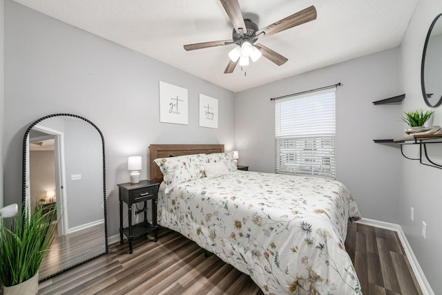 bedroom with a textured ceiling, dark hardwood / wood-style flooring, and ceiling fan