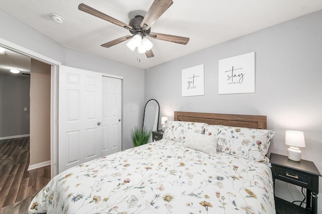 bedroom featuring dark hardwood / wood-style flooring, ceiling fan, a closet, and a textured ceiling