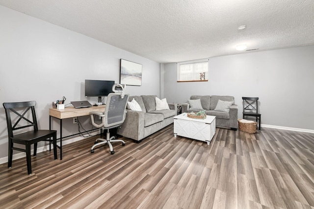 office featuring dark wood-type flooring and a textured ceiling