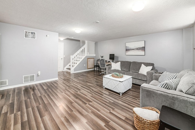 living room featuring a textured ceiling and dark hardwood / wood-style flooring