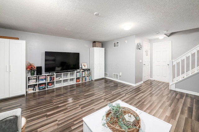 living room featuring dark wood-type flooring and a textured ceiling