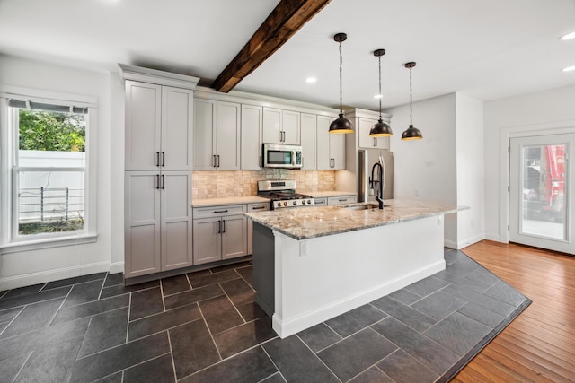 35 E Arcadia Ave, Columbus, OH 43202 - kitchen with appliances with stainless steel finishes, decorative backsplash, an island with sink, recessed lighting, and light stone counters