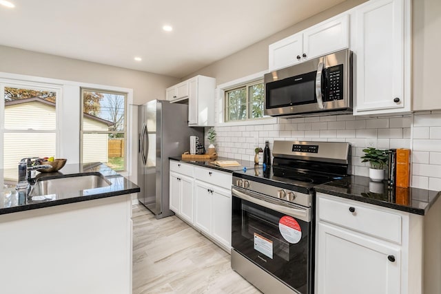 kitchen featuring white cabinetry, sink, plenty of natural light, and appliances with stainless steel finishes