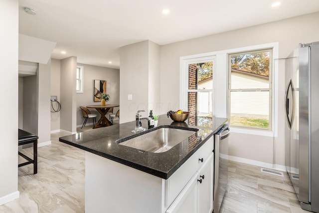 kitchen featuring white cabinets, stainless steel appliances, a healthy amount of sunlight, and sink