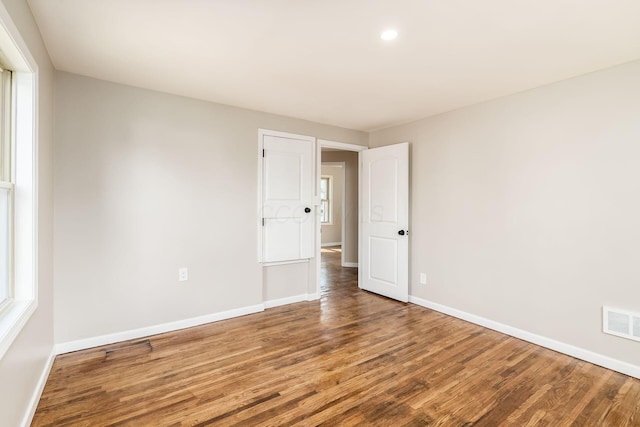 unfurnished room with hardwood / wood-style flooring