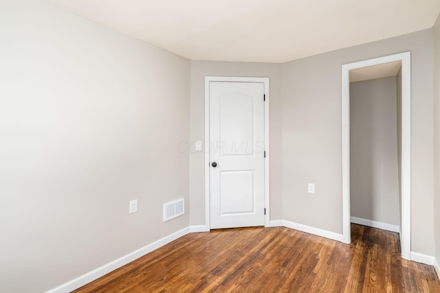 unfurnished bedroom featuring dark hardwood / wood-style floors and a closet