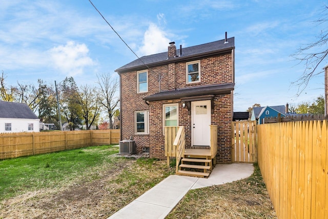 back of house with a yard and central air condition unit