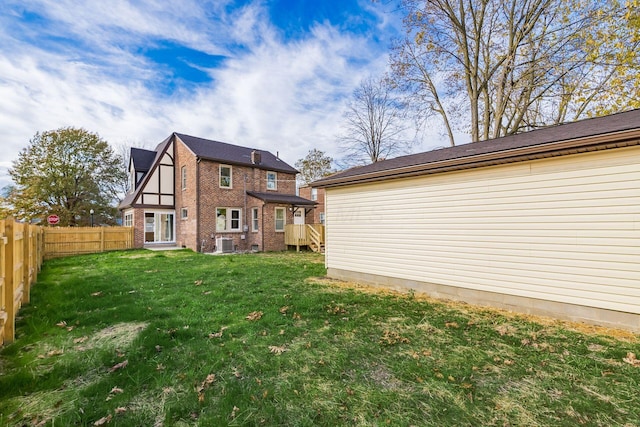 rear view of property featuring central AC and a yard