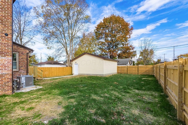 view of yard with central AC and an outbuilding