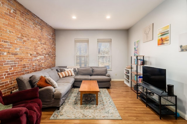 living room with hardwood / wood-style flooring and brick wall