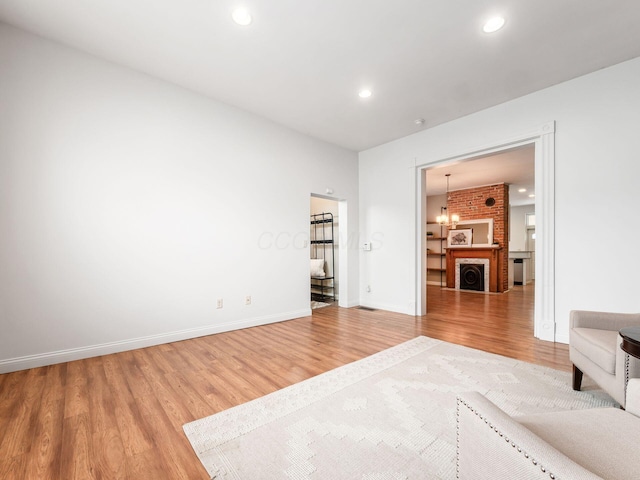 unfurnished living room with wood-type flooring and a notable chandelier