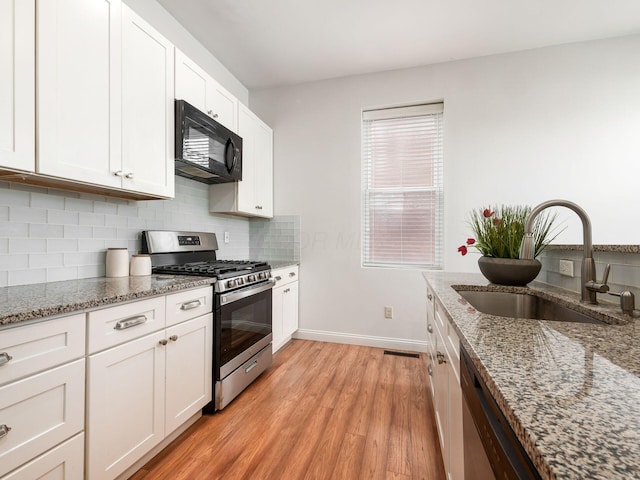 kitchen featuring light stone counters, sink, white cabinetry, and stainless steel appliances