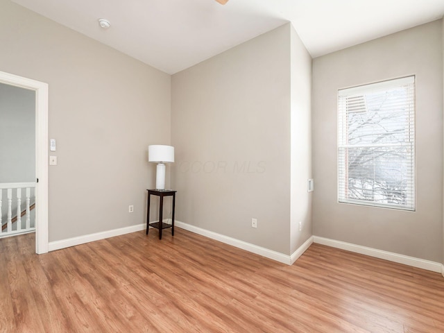 spare room with light wood-type flooring and a wealth of natural light