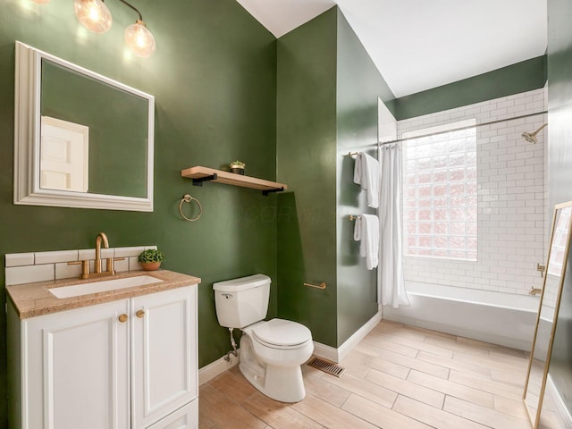 full bathroom featuring toilet, shower / bath combination with curtain, and vanity