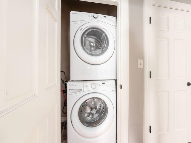 clothes washing area featuring stacked washer and clothes dryer