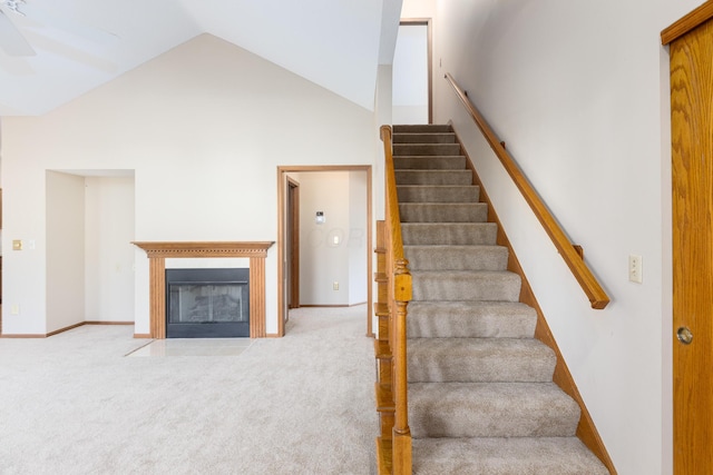 stairs with carpet floors and high vaulted ceiling