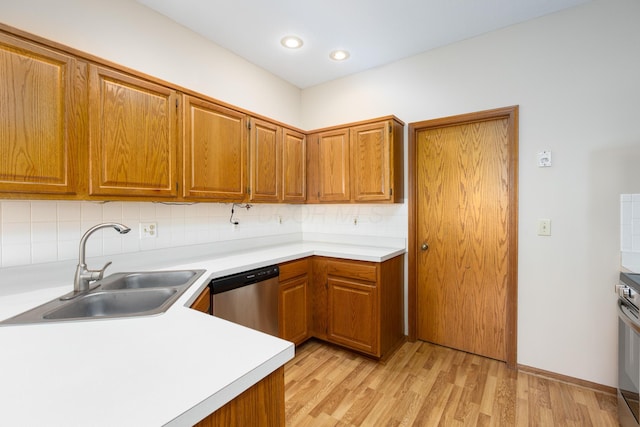 kitchen with decorative backsplash, stainless steel appliances, light hardwood / wood-style floors, and sink