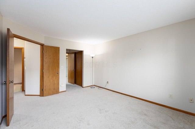 unfurnished room featuring light carpet