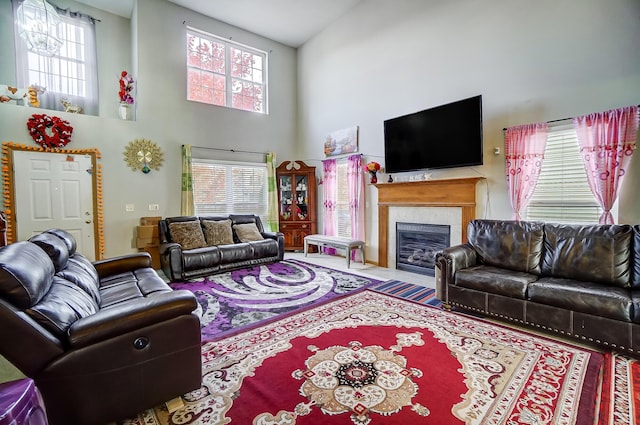 living room with a tile fireplace and high vaulted ceiling