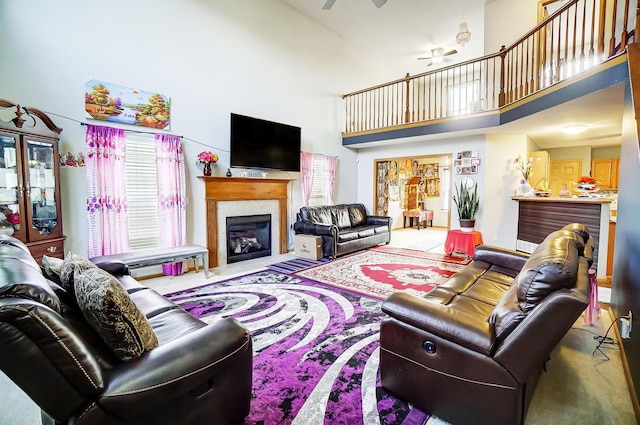 living room with a fireplace, a high ceiling, carpet floors, and ceiling fan