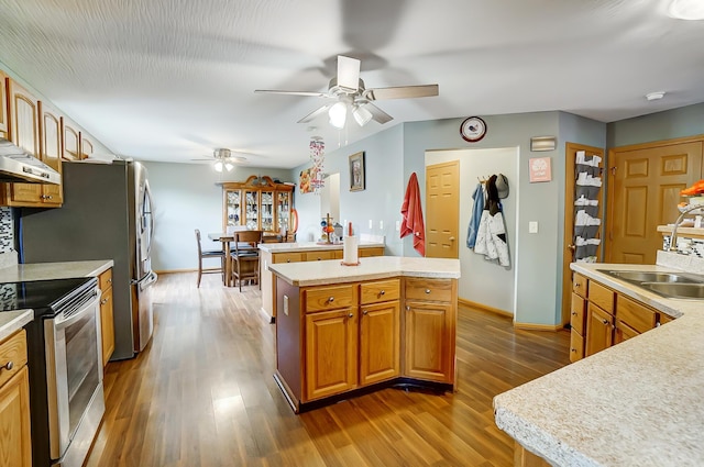 kitchen with dark hardwood / wood-style flooring, a kitchen island, and stainless steel range with electric stovetop