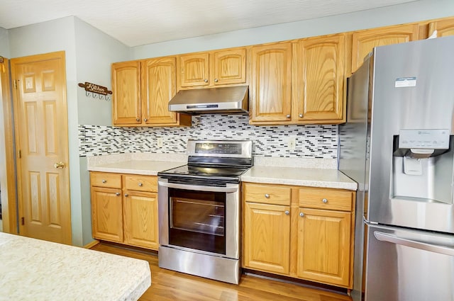 kitchen featuring backsplash, light hardwood / wood-style flooring, and stainless steel appliances