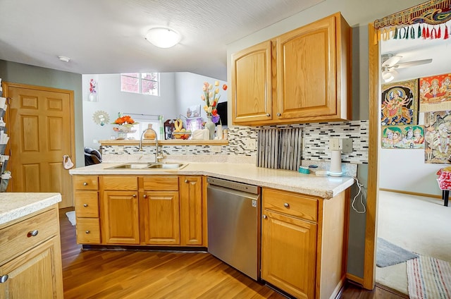 kitchen featuring tasteful backsplash, stainless steel dishwasher, ceiling fan, dark wood-type flooring, and sink