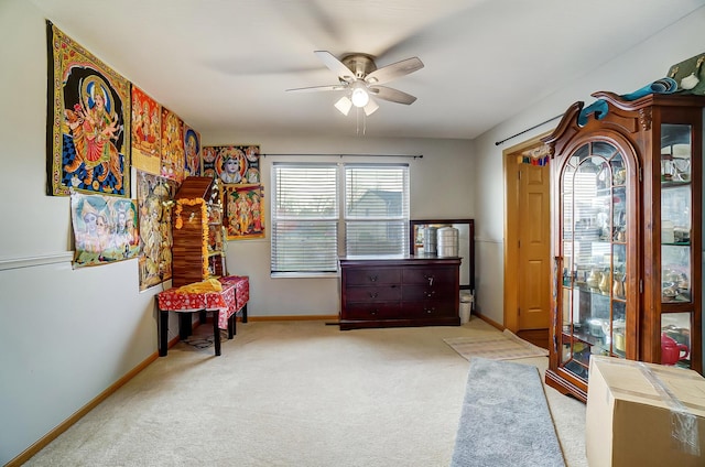 living area featuring light carpet and ceiling fan