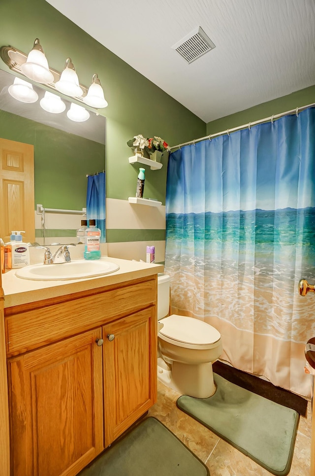 bathroom featuring tile patterned floors, vanity, and toilet