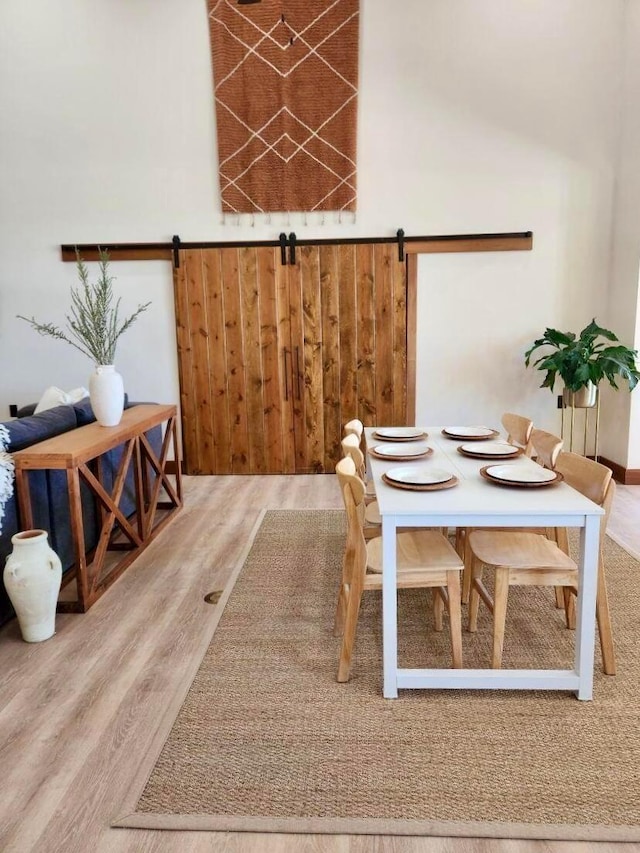 dining area featuring hardwood / wood-style floors and a barn door