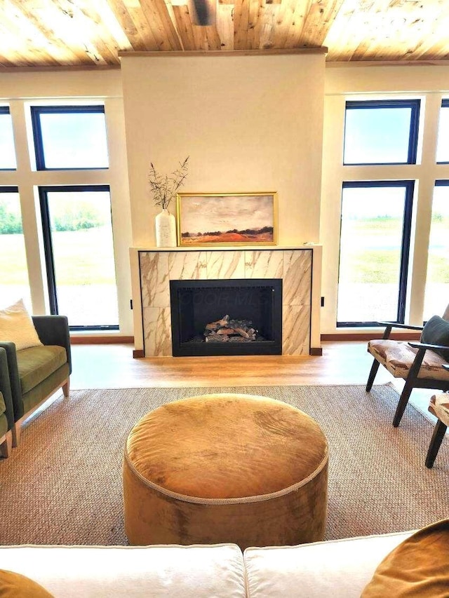 living room with a high end fireplace and wooden ceiling