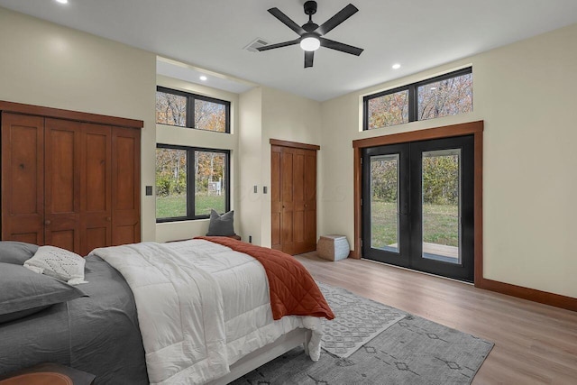 bedroom with access to outside, light hardwood / wood-style flooring, multiple windows, and ceiling fan