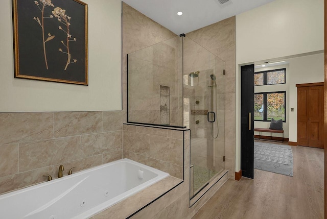 bathroom with plus walk in shower and hardwood / wood-style flooring