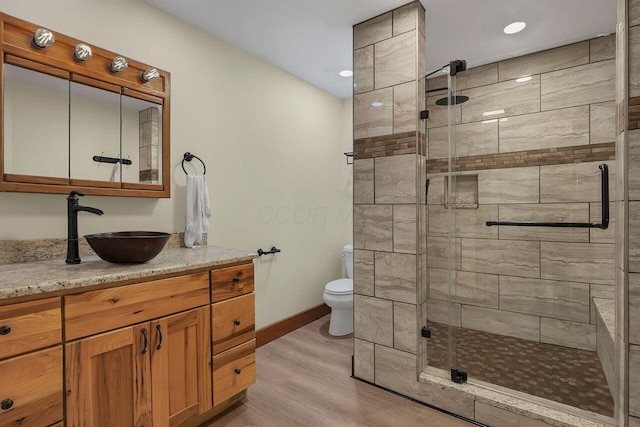 bathroom featuring vanity, hardwood / wood-style flooring, toilet, and an enclosed shower