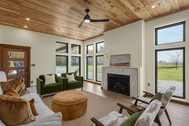 living room with a healthy amount of sunlight, light wood-type flooring, and wooden ceiling