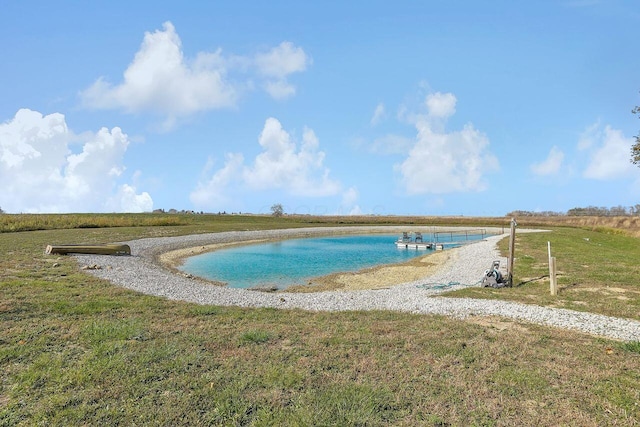 view of pool featuring a yard and a water view