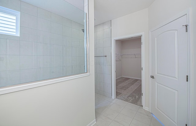 bathroom featuring tile patterned flooring and tiled shower