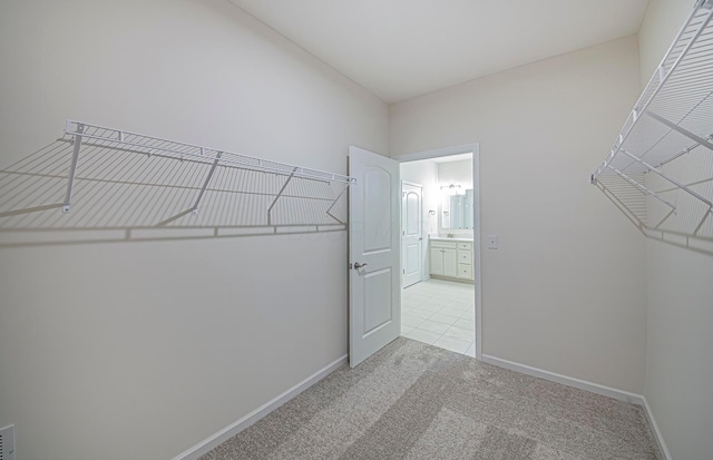 walk in closet featuring light colored carpet