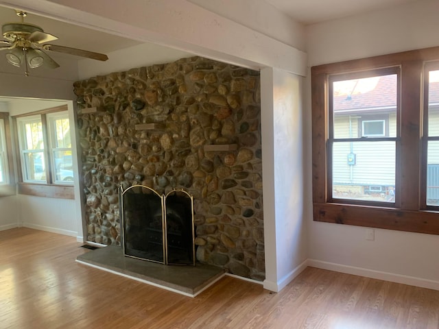 unfurnished living room with a fireplace, light hardwood / wood-style floors, and ceiling fan