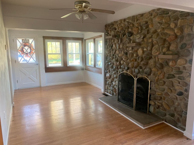 unfurnished living room with a fireplace, light hardwood / wood-style flooring, and ceiling fan