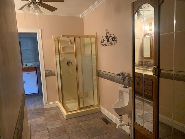 bathroom featuring tile patterned flooring, a shower with shower door, ceiling fan, and ornamental molding