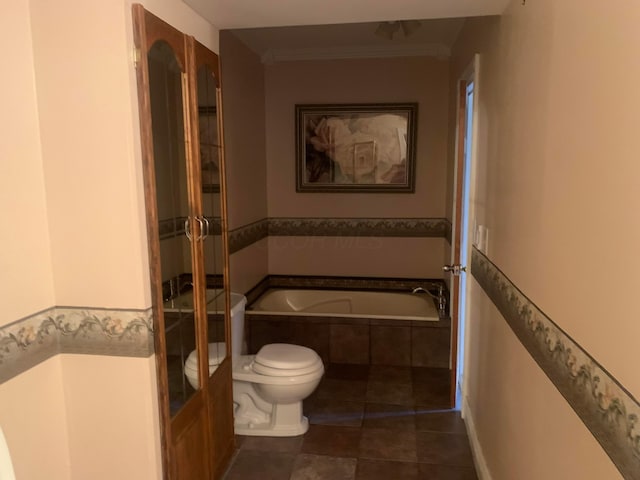 bathroom featuring crown molding, a relaxing tiled tub, and toilet