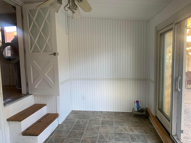 unfurnished sunroom featuring ceiling fan