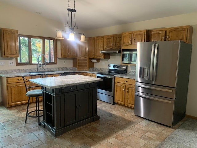 kitchen with sink, pendant lighting, vaulted ceiling, a kitchen island, and appliances with stainless steel finishes