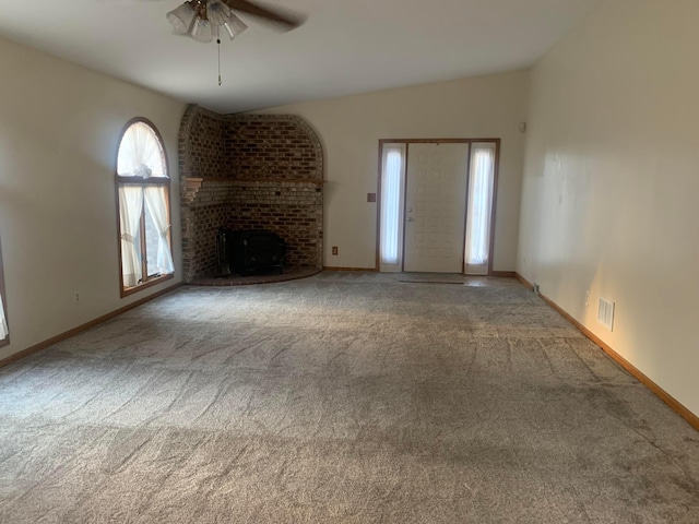 unfurnished living room with ceiling fan, carpet floors, a fireplace, and vaulted ceiling