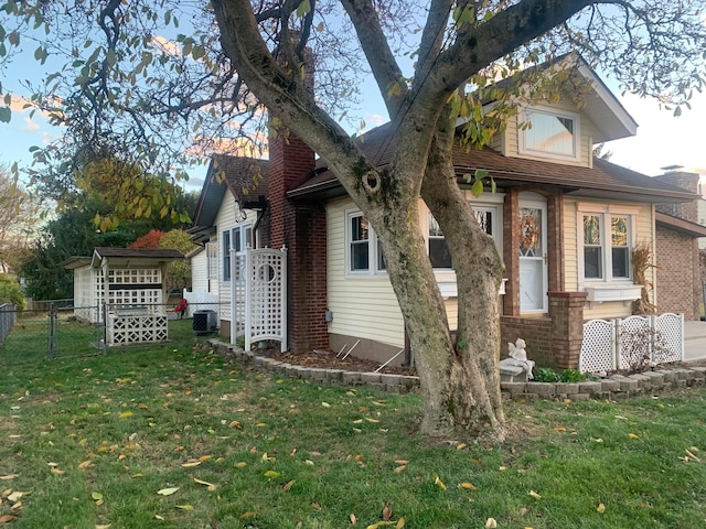 view of side of property with a lawn and central AC