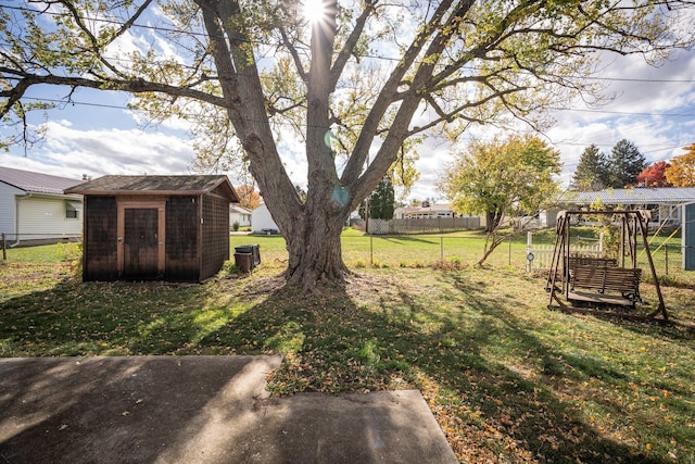 view of yard with fence, an outdoor structure, and a storage unit