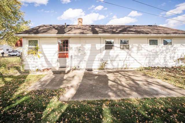 back of property featuring a chimney, fence, and a patio