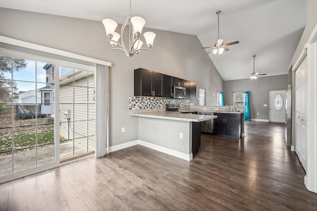 kitchen featuring ceiling fan with notable chandelier, dark hardwood / wood-style flooring, kitchen peninsula, and appliances with stainless steel finishes